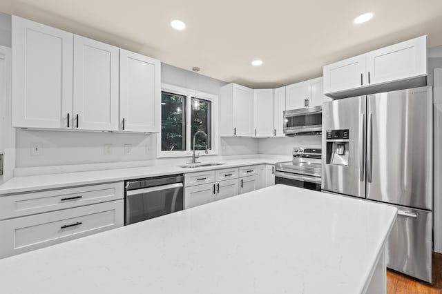 7 Woodmont Rd, Avon, CT 06001 - kitchen featuring appliances with stainless steel finishes, white cabinets, recessed lighting, wood finished floors, and light stone counters