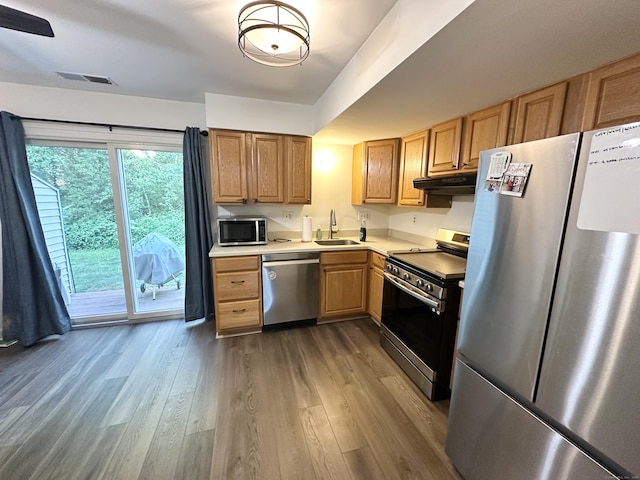 63 Coleman St Apt 14, East Haven, CT 06512 - kitchen featuring appliances with stainless steel finishes, under cabinet range hood, wood finished floors, and light countertops