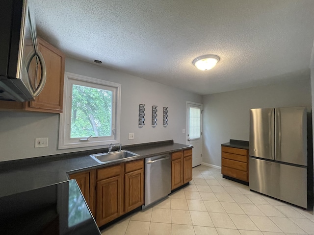 56 Elm St Apt 36, Enfield, CT 06082 - kitchen with stainless steel appliances, brown cabinets, a textured ceiling, healthy amount of natural light, and dark countertops