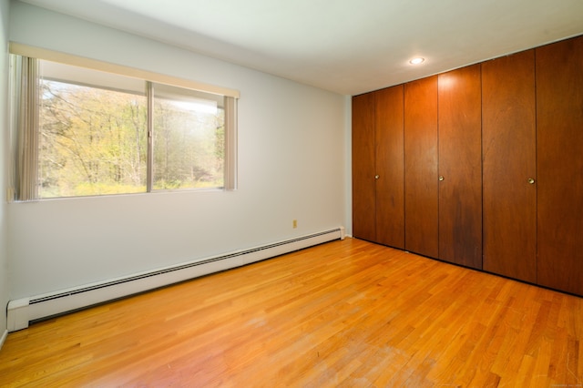 87 Pleasant Dr, Bethany, CT 06524 - unfurnished bedroom with a baseboard radiator, light wood finished floors, recessed lighting, and a closet