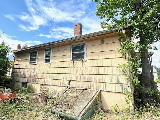 65 Masarik Ave, Stratford, CT 06615 - view of home's exterior with a chimney