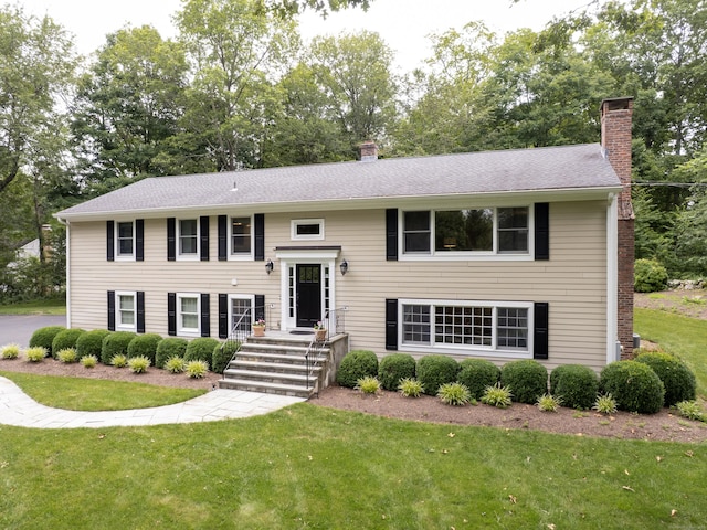 58 Longmeadows Rd, Wilton, CT 06897 - split foyer home with a chimney, a front lawn, and view of wooded area