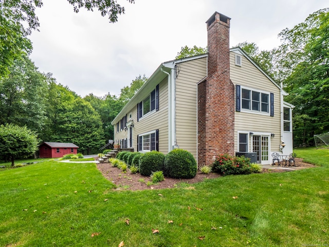 58 Longmeadows Rd, Wilton, CT 06897 - view of home's exterior featuring a chimney, a lawn, a patio area, and an outbuilding