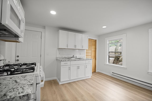 220 Hillside Ave, Waterbury, CT 06710 - kitchen with white appliances, baseboard heating, light wood-style floors, white cabinets, and backsplash