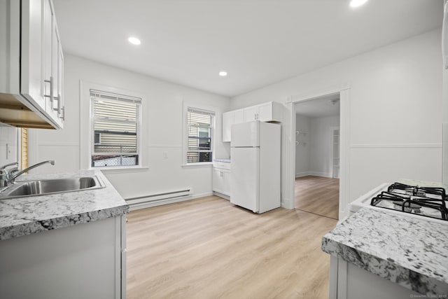 220 Hillside Ave, Waterbury, CT 06710 - kitchen with white appliances, a baseboard heating unit, light wood-style flooring, white cabinetry, and light countertops