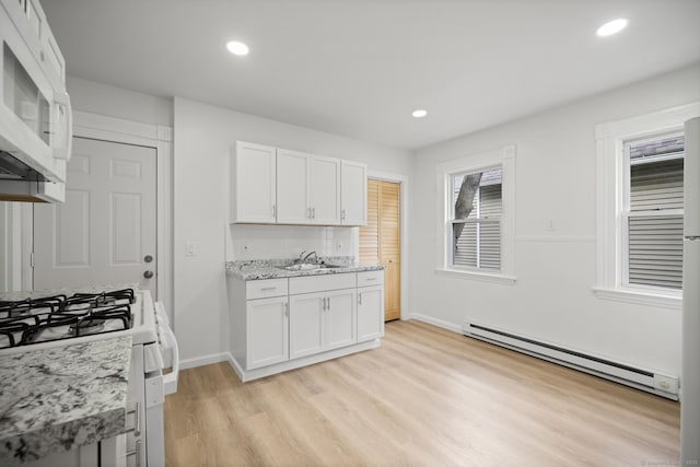 220 Hillside Ave, Waterbury, CT 06710 - kitchen with a baseboard heating unit, white appliances, light wood-style flooring, white cabinetry, and recessed lighting