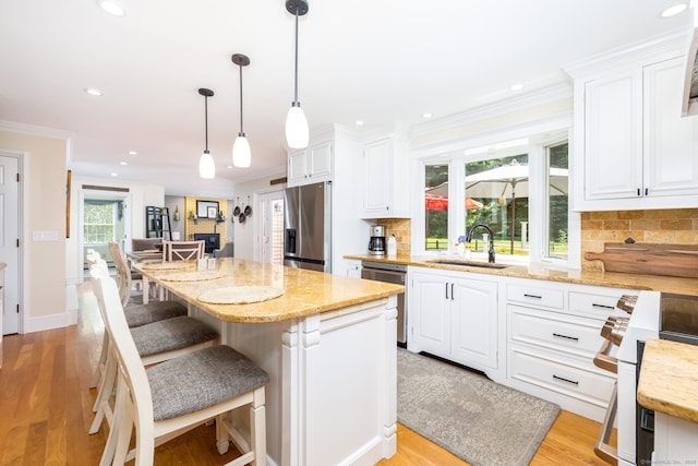 89 Honey Hill Rd, New Hartford, CT 06057 - kitchen with appliances with stainless steel finishes, white cabinetry, decorative backsplash, a breakfast bar area, and crown molding