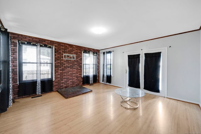 53 Wells Ave, East Hartford, CT 06108 - unfurnished living room with brick wall, light wood-style flooring, plenty of natural light, and ornamental molding