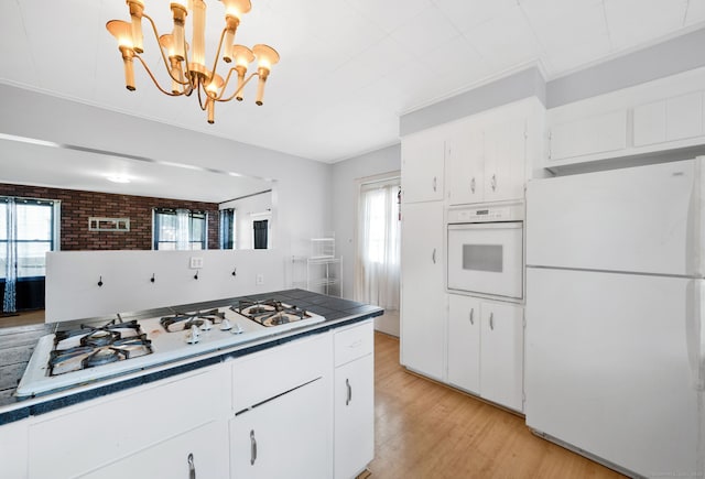 53 Wells Ave, East Hartford, CT 06108 - kitchen with white appliances, light wood-type flooring, healthy amount of natural light, and white cabinets