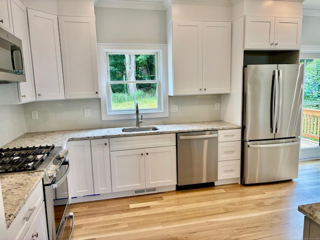 2 Gary Knls, Danbury, CT 06810 - kitchen featuring appliances with stainless steel finishes, crown molding, light wood-style floors, white cabinetry, and light stone countertops