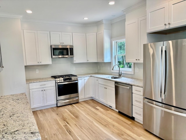 2 Gary Knls, Danbury, CT 06810 - kitchen featuring stainless steel appliances, crown molding, white cabinetry, light wood finished floors, and light stone countertops
