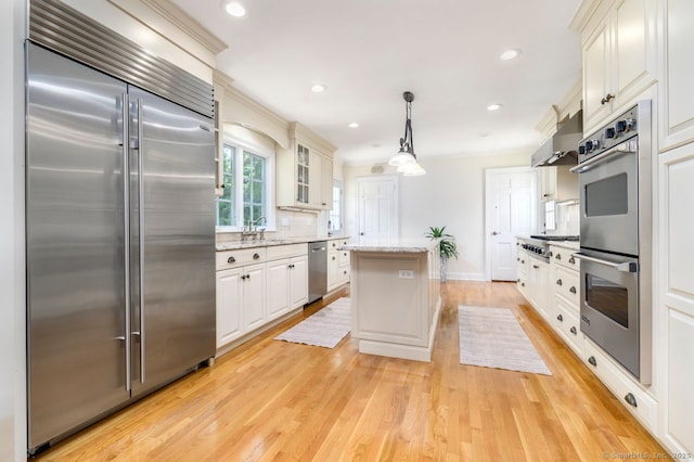 285 Westover Rd, Stamford, CT 06902 - kitchen featuring stainless steel appliances, exhaust hood, a kitchen island, decorative backsplash, and light stone counters