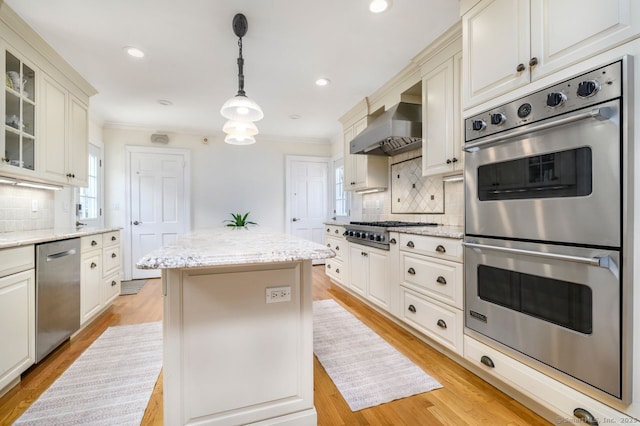 285 Westover Rd, Stamford, CT 06902 - kitchen featuring appliances with stainless steel finishes, wall chimney exhaust hood, a center island, ornamental molding, and decorative backsplash