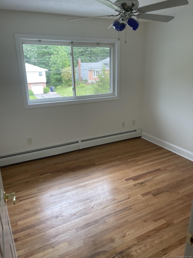 37 W Normandy Dr, West Hartford, CT 06107 - empty room with healthy amount of natural light, a ceiling fan, a baseboard heating unit, and light wood-type flooring