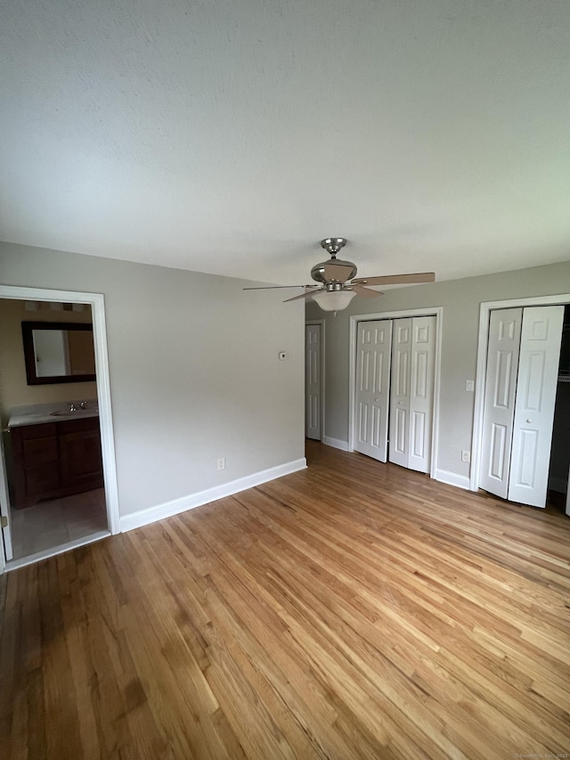 37 W Normandy Dr, West Hartford, CT 06107 - unfurnished bedroom featuring light wood-style flooring, multiple closets, ceiling fan, and ensuite bathroom