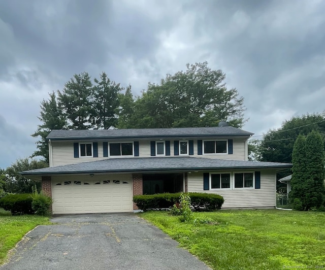 37 W Normandy Dr, West Hartford, CT 06107 - view of front of property with driveway, a front lawn, an attached garage, a chimney, and brick siding