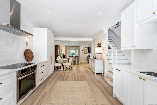 10 Pine Brook Ln Unit 10, Darien, CT 06820 - kitchen featuring wall chimney range hood, oven, black electric stovetop, ornamental molding, and light wood finished floors