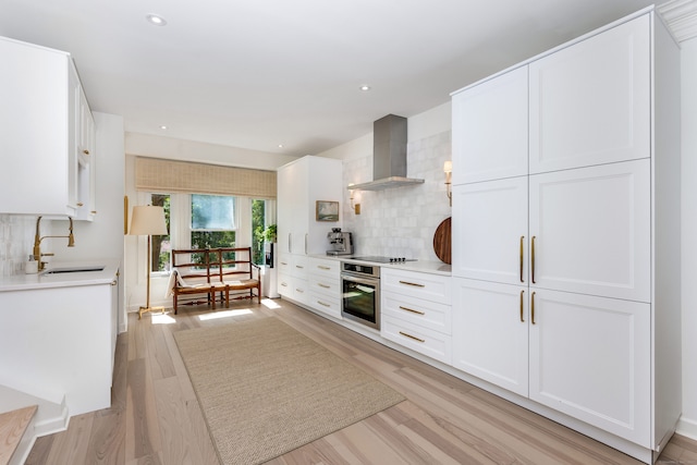 10 Pine Brook Ln Unit 10, Darien, CT 06820 - kitchen with wall chimney exhaust hood, stainless steel oven, backsplash, white cabinets, and light countertops