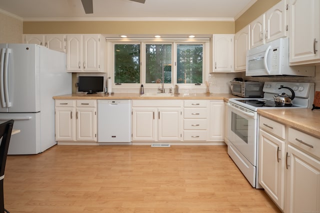 29 S Village Rd Unit 29, Branford, CT 06405 - kitchen featuring white appliances, white cabinets, crown molding, light countertops, and light wood-type flooring