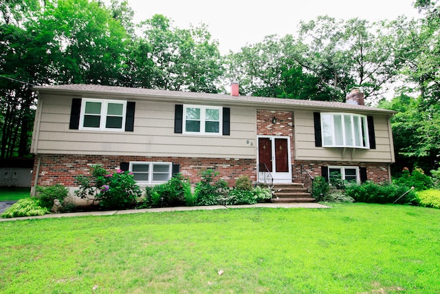 95 Laurelbrook Dr, Guilford, CT 06437 - raised ranch with a chimney, brick siding, a front lawn, and view of scattered trees