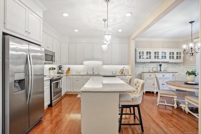 7 Still Water Cir Unit 7, Brookfield, CT 06804 - kitchen with stainless steel appliances, a kitchen breakfast bar, ornamental molding, white cabinetry, and recessed lighting