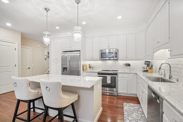 7 Still Water Cir Unit 7, Brookfield, CT 06804 - kitchen featuring appliances with stainless steel finishes, a center island, a kitchen bar, tasteful backsplash, and white cabinetry