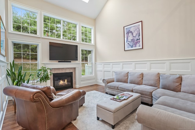 7 Still Water Cir Unit 7, Brookfield, CT 06804 - living room with a tiled fireplace, high vaulted ceiling, wood finished floors, a wainscoted wall, and a decorative wall