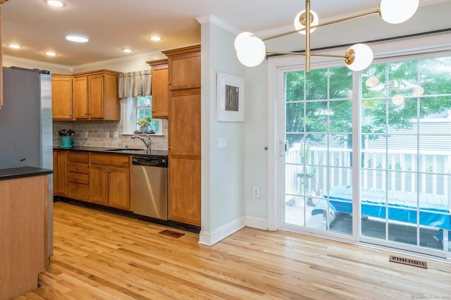 38 Stuart Ave Apt C, Norwalk, CT 06850 - kitchen featuring appliances with stainless steel finishes, brown cabinets, crown molding, plenty of natural light, and recessed lighting