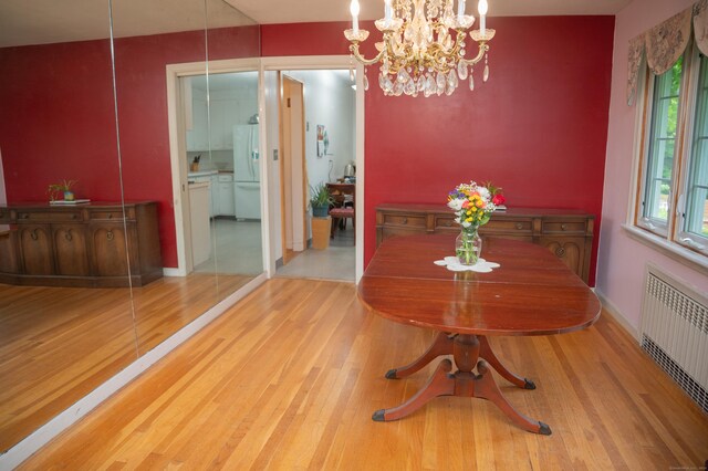 780 Ridge Rd, Hamden, CT 06517 - dining space featuring radiator heating unit, wood finished floors, and a chandelier