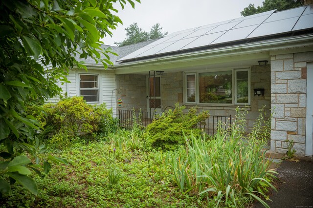 780 Ridge Rd, Hamden, CT 06517 - view of exterior entry featuring stone siding, solar panels, and covered porch