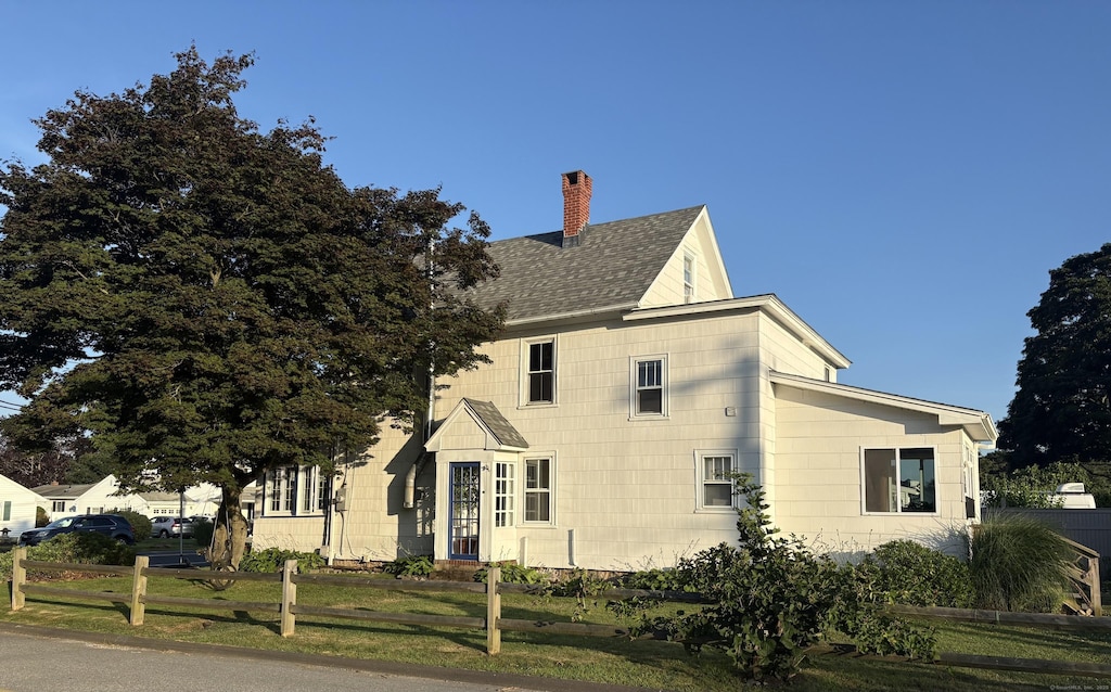 53 Smith St, East Lyme, CT 06357 - view of home's exterior featuring a chimney and roof with shingles