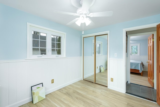 92 Grove Beach Rd S, Westbrook, CT 06498 - unfurnished bedroom featuring light wood finished floors, a wainscoted wall, a closet, and ceiling fan