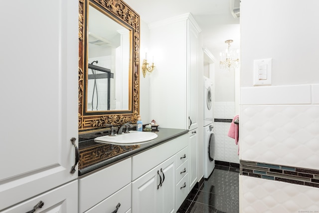 92 Grove Beach Rd S, Westbrook, CT 06498 - bathroom featuring stacked washer / dryer, a chandelier, vanity, tile walls, and tile patterned flooring