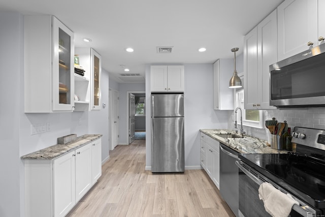5 Fuller Ct, East Lyme, CT 06357 - kitchen with stainless steel appliances, white cabinets, light stone countertops, light wood-type flooring, and recessed lighting