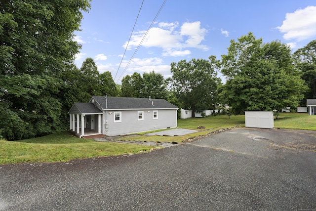5 Fuller Ct, East Lyme, CT 06357 - view of front of house featuring a front yard, driveway, and a storage unit