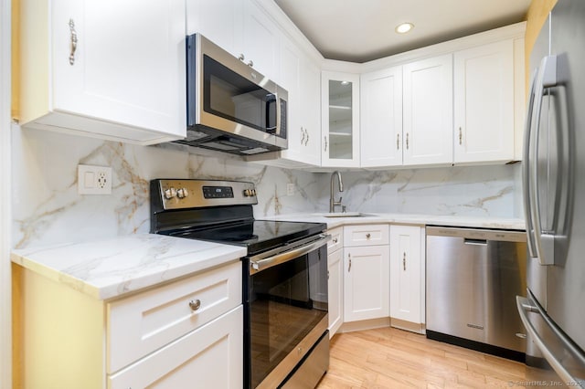 1197 Hope St Apt 7, Stamford, CT 06907 - kitchen featuring appliances with stainless steel finishes, light stone counters, white cabinetry, and recessed lighting
