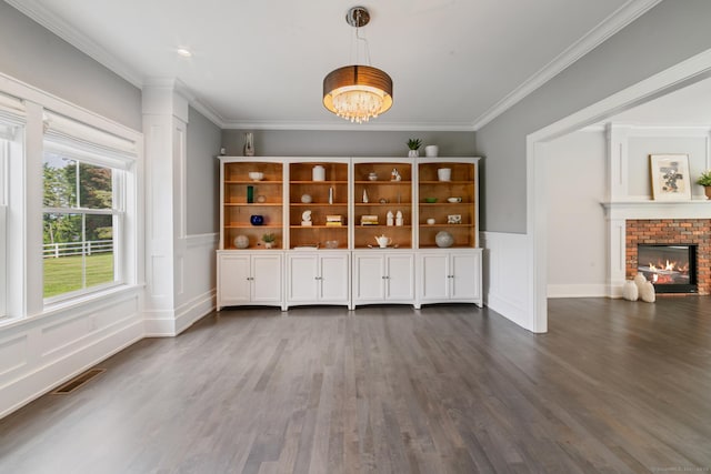 98A Tower Rd, Brookfield, CT 06804 - unfurnished living room featuring a chandelier, wood finished floors, ornamental molding, a brick fireplace, and wainscoting