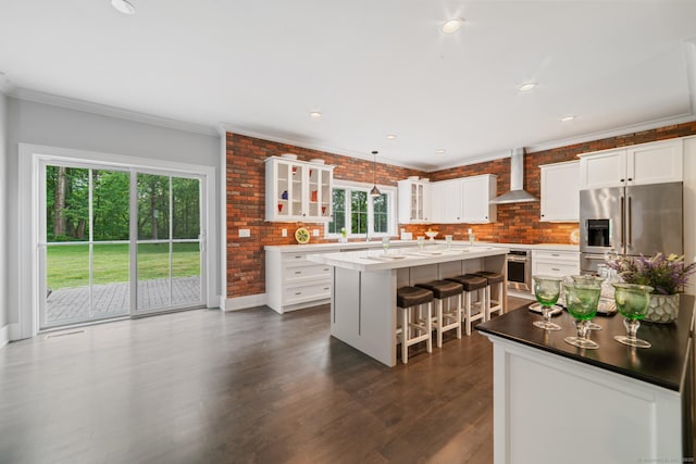 98A Tower Rd, Brookfield, CT 06804 - kitchen featuring stainless steel appliances, wall chimney exhaust hood, an island with sink, glass insert cabinets, and crown molding