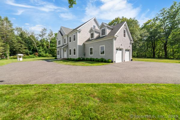 98A Tower Rd, Brookfield, CT 06804 - view of home's exterior featuring a garage, asphalt driveway, and a lawn