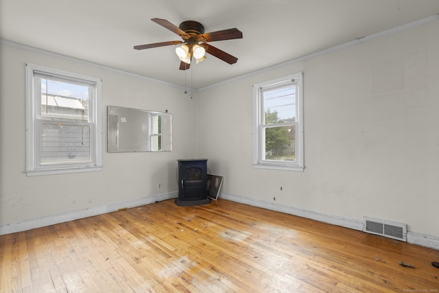 484 Reitter St W, Stratford, CT 06614 - empty room with a wood stove, ornamental molding, wood-type flooring, and ceiling fan