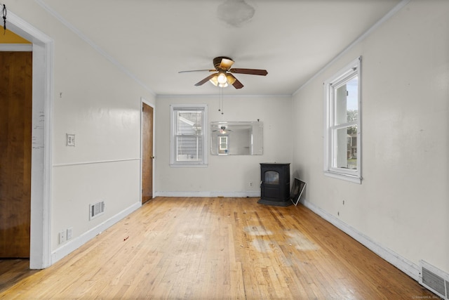 484 Reitter St W, Stratford, CT 06614 - unfurnished living room with a wood stove, a ceiling fan, wood-type flooring, and crown molding