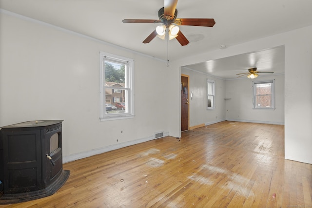 484 Reitter St W, Stratford, CT 06614 - unfurnished living room with a wood stove, a ceiling fan, light wood-type flooring, and crown molding