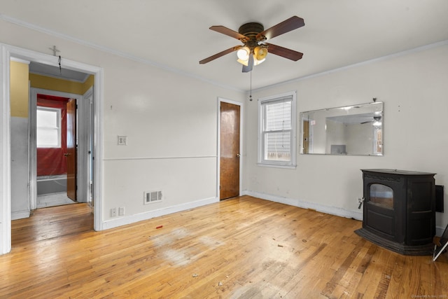 484 Reitter St W, Stratford, CT 06614 - unfurnished living room featuring a wood stove, a ceiling fan, crown molding, and hardwood / wood-style flooring
