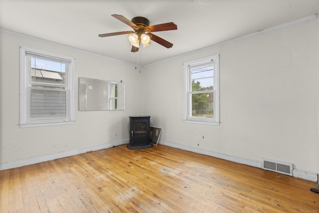484 Reitter St W, Stratford, CT 06614 - empty room featuring a wood stove, crown molding, light wood finished floors, and ceiling fan