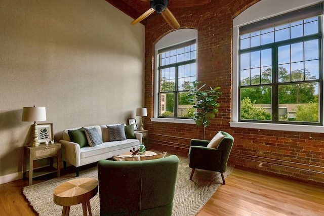 33 Mechanic St Unit 204, Windsor, CT 06095 - living room featuring brick wall, light wood-type flooring, a ceiling fan, beam ceiling, and a high ceiling