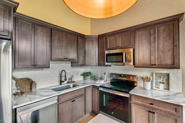 33 Mechanic St Unit 204, Windsor, CT 06095 - kitchen featuring appliances with stainless steel finishes, backsplash, dark brown cabinets, and light stone counters