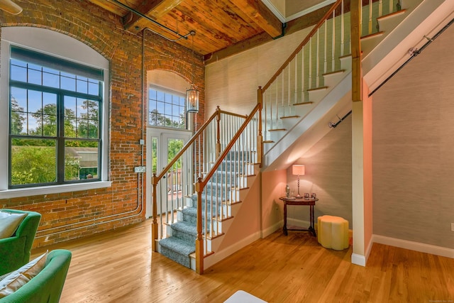 33 Mechanic St Unit 204, Windsor, CT 06095 - staircase with wood finished floors, brick wall, a towering ceiling, and a wood ceiling with exposed beams