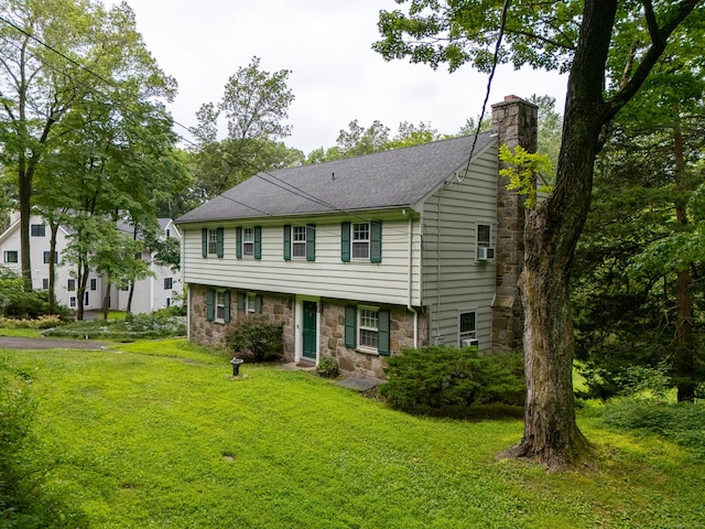 226 Stanwich Rd, Greenwich, CT 06830 - colonial-style house with stone siding, a chimney, a front lawn, and roof with shingles