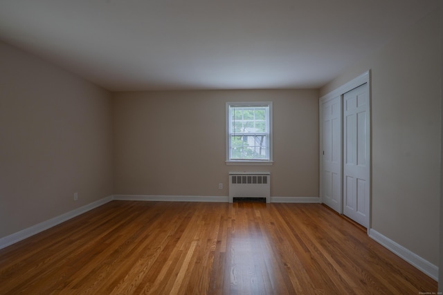 226 Stanwich Rd, Greenwich, CT 06830 - unfurnished bedroom featuring wood finished floors, radiator heating unit, and a closet