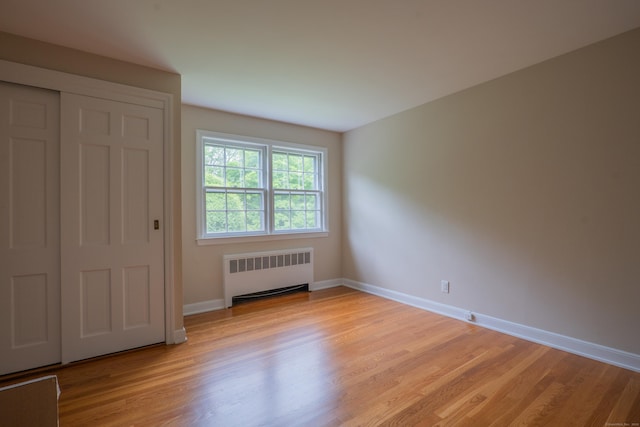 226 Stanwich Rd, Greenwich, CT 06830 - unfurnished bedroom with radiator heating unit, light wood finished floors, and a closet